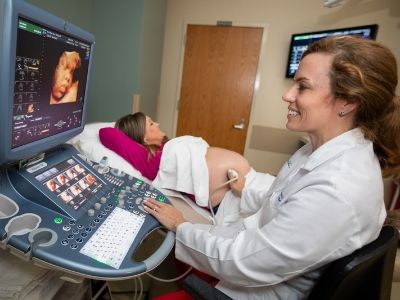 Female physician performs expectant mother's 3D sonogram